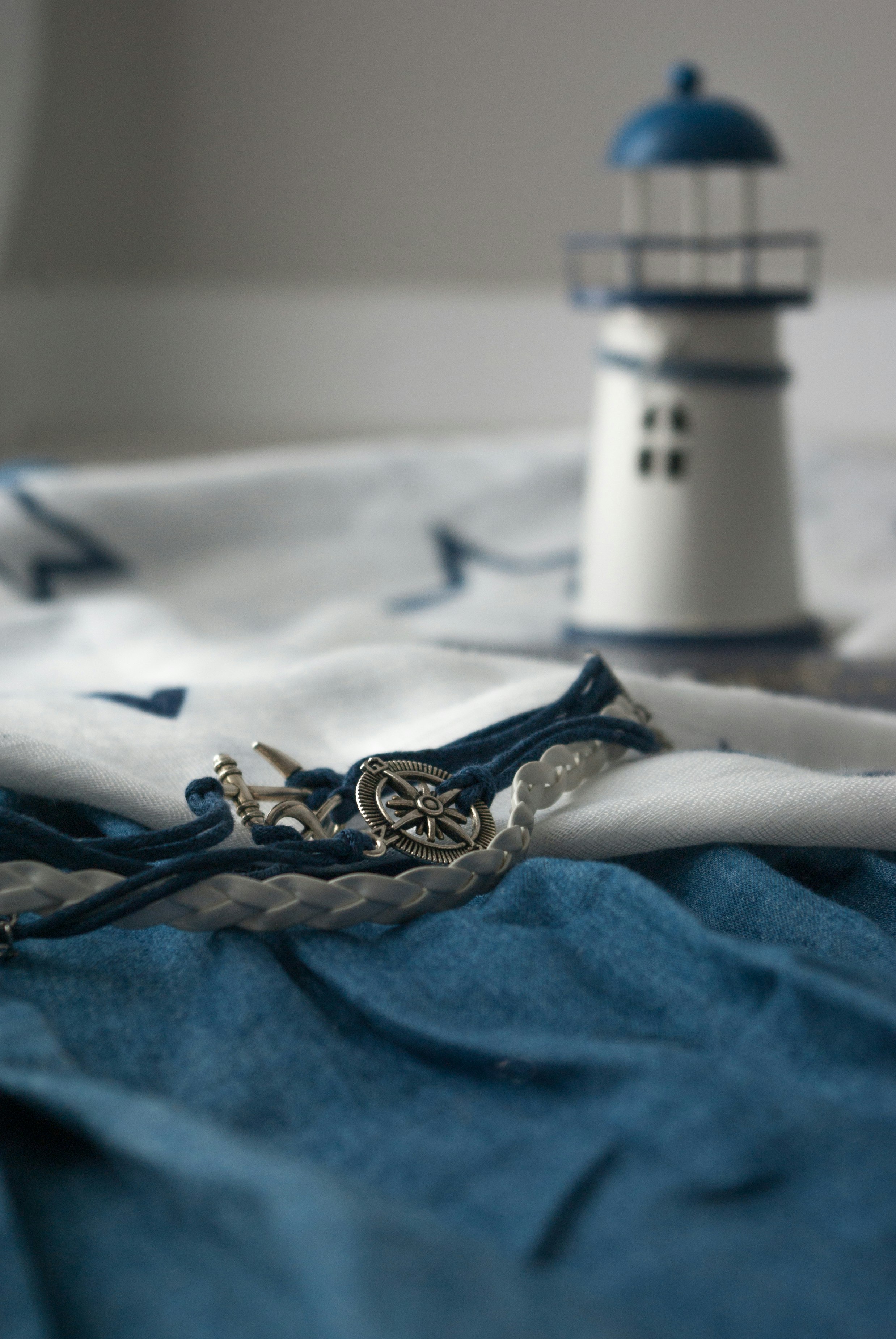 silver and white round pendant necklace on blue textile